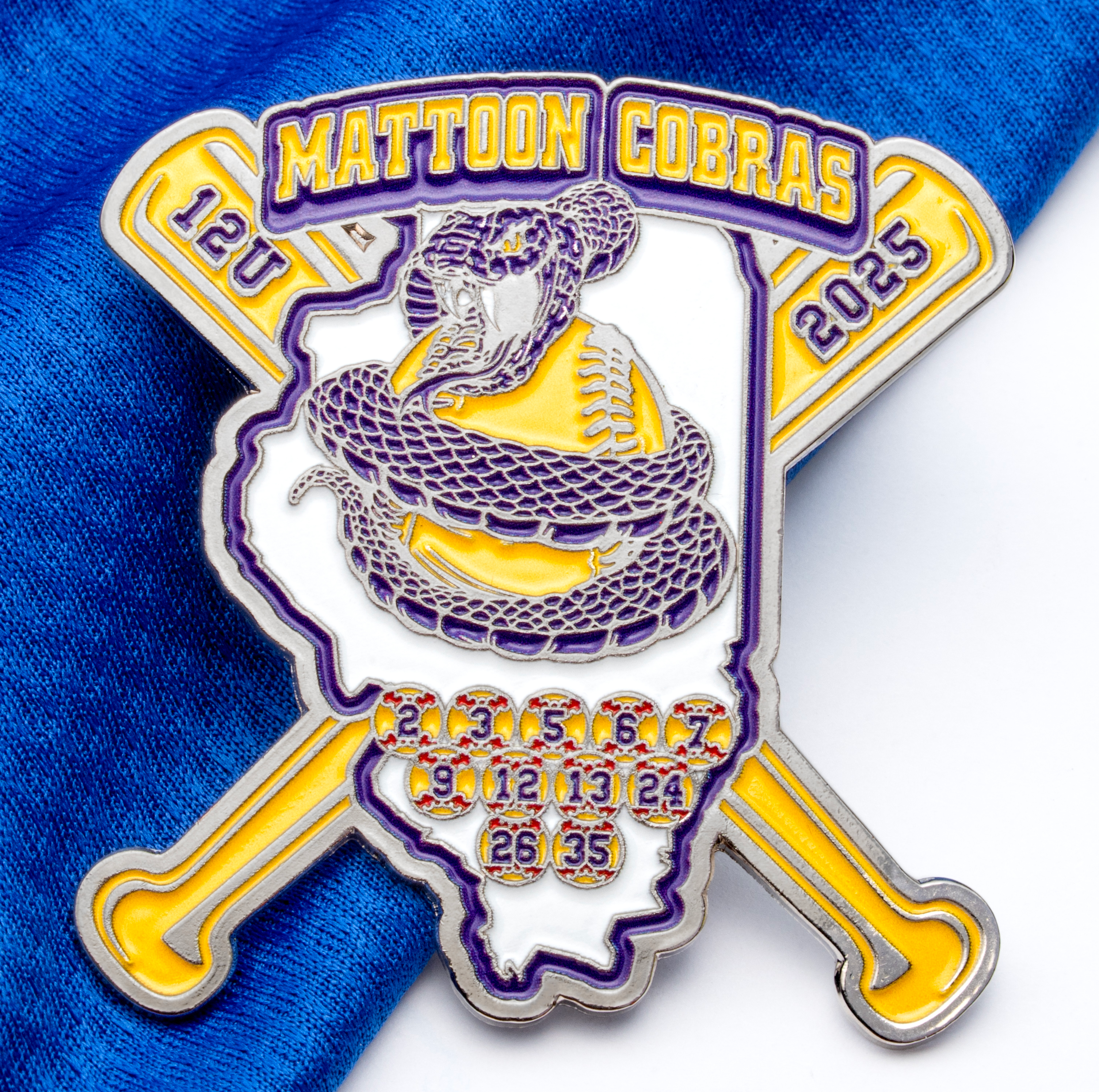 Enamel trading pin for Mattoon Cobras 12U 2025 featuring a snake coiled around a softball on crossed bats with player numbers.
