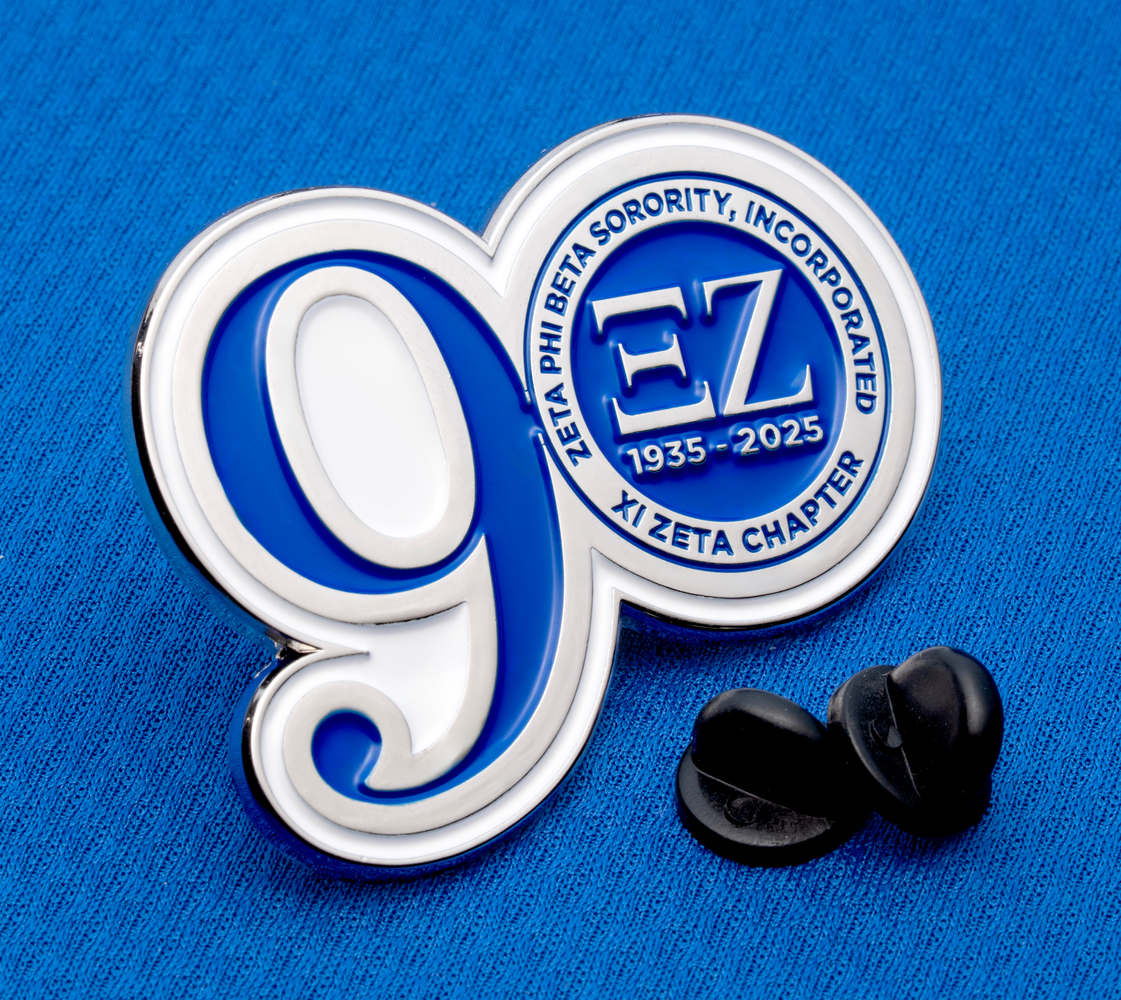 map[name:Enamel lapel pin with a large white and blue number 9 and a circular seal for Zeta Phi Beta Sorority, Xi Zeta Chapter, featuring greek letters and years 1935-20 naturalSort:Enamel lapel pin with a large white and blue number 00000000000000000000000000000009.00000000000000000000000000000000  and a circular seal for Zeta Phi Beta Sorority, Xi Zeta Chapter, featuring greek letters and years 00000000000000000000000000001935.00000000000000000000000000000000 -00000000000000000000000000000020.00000000000000000000000000000000 ]