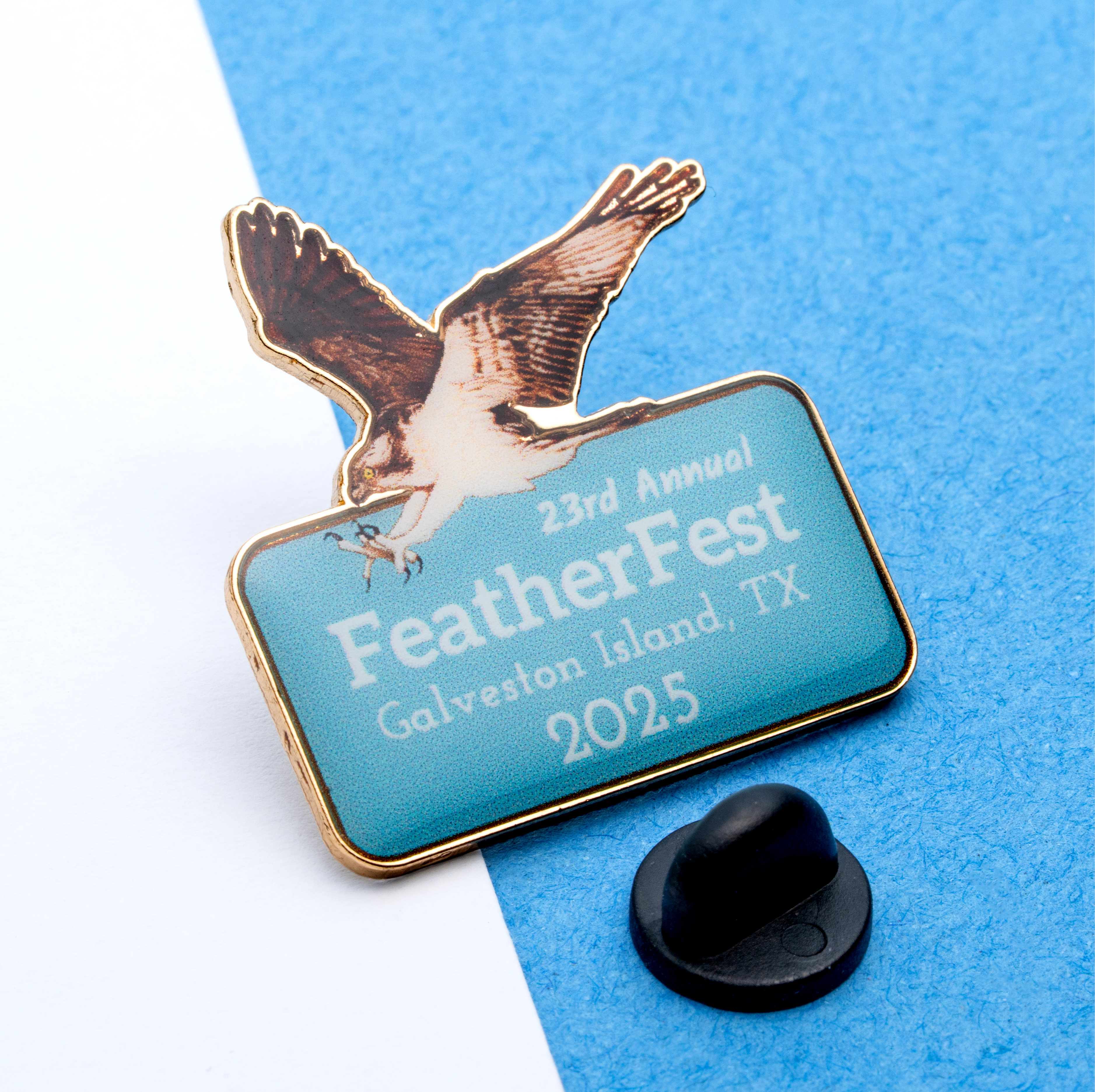 map[name:Custom lapel pin featuring an osprey in flight above a light blue rectangle with FeatherFest 2025 Galveston Island, TX text. naturalSort:Custom lapel pin featuring an osprey in flight above a light blue rectangle with FeatherFest 00000000000000000000000000002025.00000000000000000000000000000000  Galveston Island, TX text.]