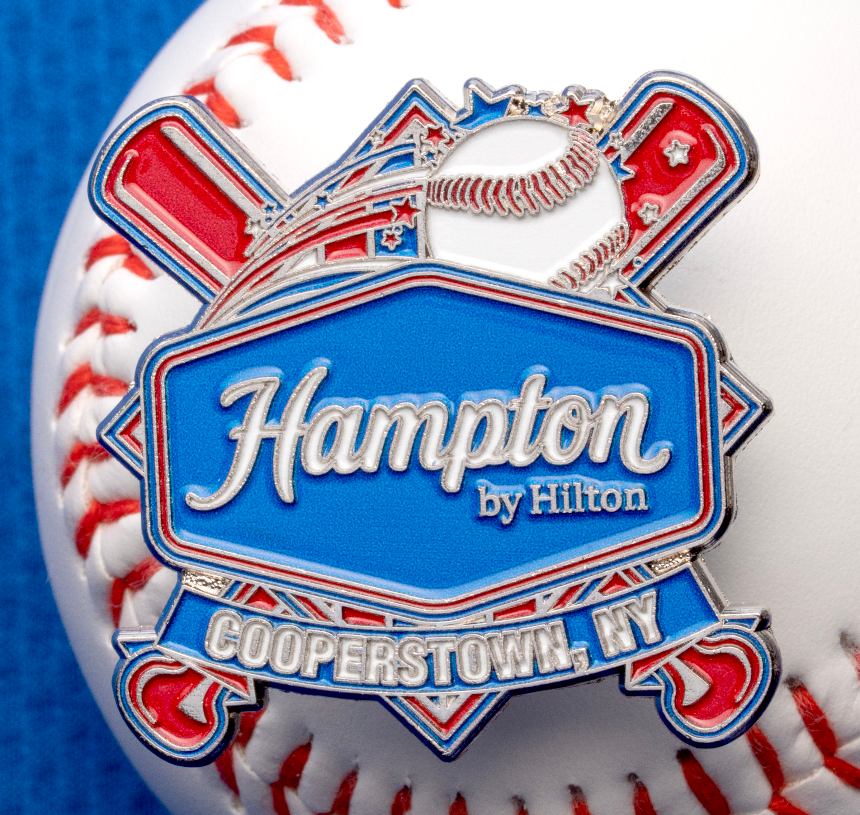 map[name:Soft enamel lapel pin for Hampton by Hilton Cooperstown featuring a baseball, crossed bats, and stars, resting on a white baseball. naturalSort:Soft enamel lapel pin for Hampton by Hilton Cooperstown featuring a baseball, crossed bats, and stars, resting on a white baseball.]