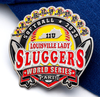 Custom softball trading pin for Louisville Lady Sluggers 2025 World Series Paris featuring player names and numbers on a blue cap.