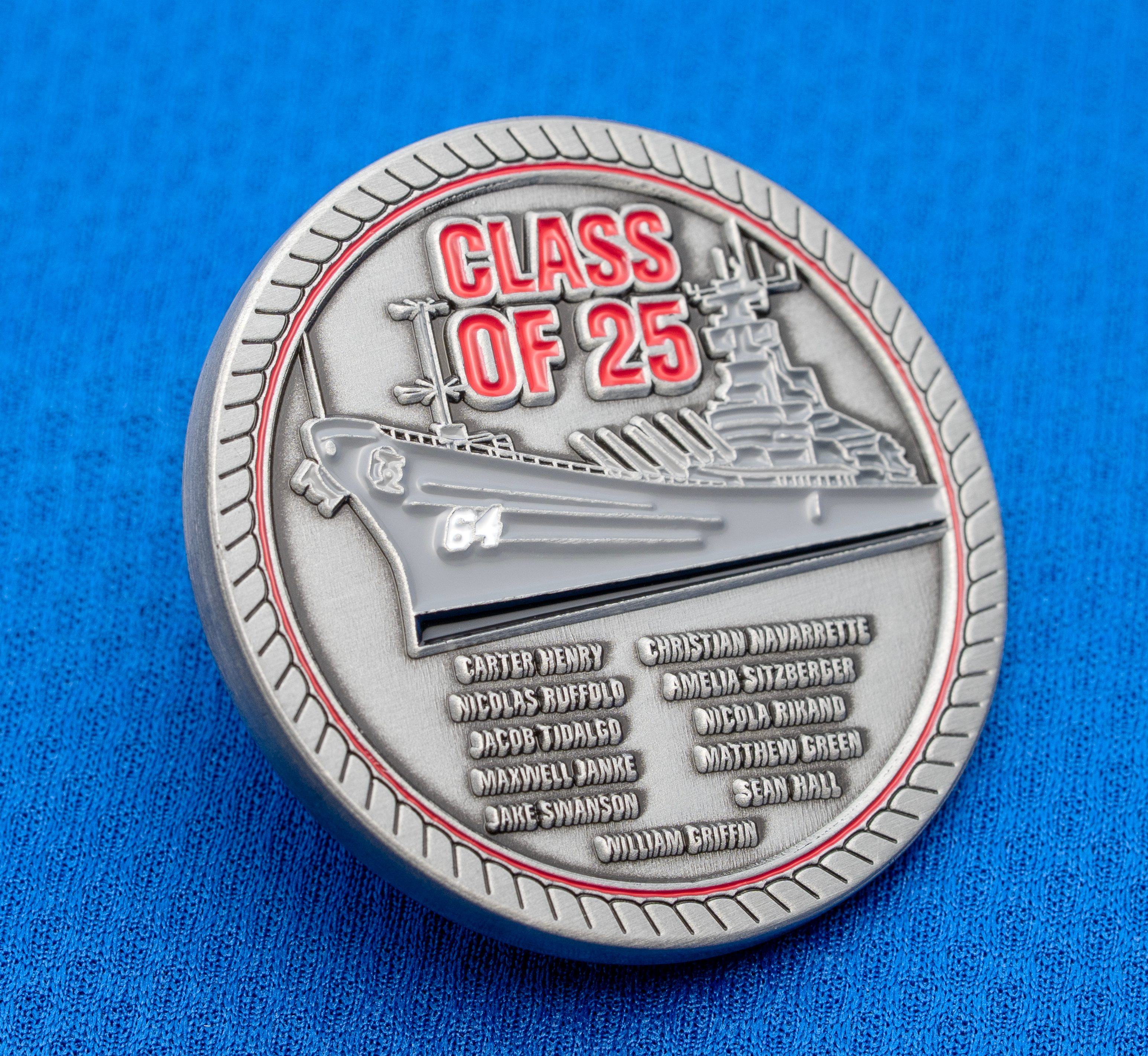 map[name:Circular silver challenge coin featuring a battleship with red 'Class of 25' text and a list of names, resting on a blue textured background. naturalSort:Circular silver challenge coin featuring a battleship with red 'Class of 00000000000000000000000000000025.00000000000000000000000000000000 ' text and a list of names, resting on a blue textured background.]