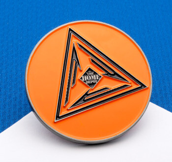Circular orange enamel pin featuring a black and silver triangle design with The Home Depot logo in the center.
