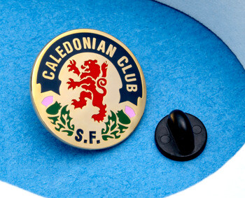 Circular gold enamel lapel pin for Caledonian Club S.F. featuring a red lion rampant and thistle design on a blue background.