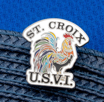 Soft enamel lapel pin featuring a colorful rooster with St. Croix and U.S.V.I. text, pinned to a navy woven hat brim.