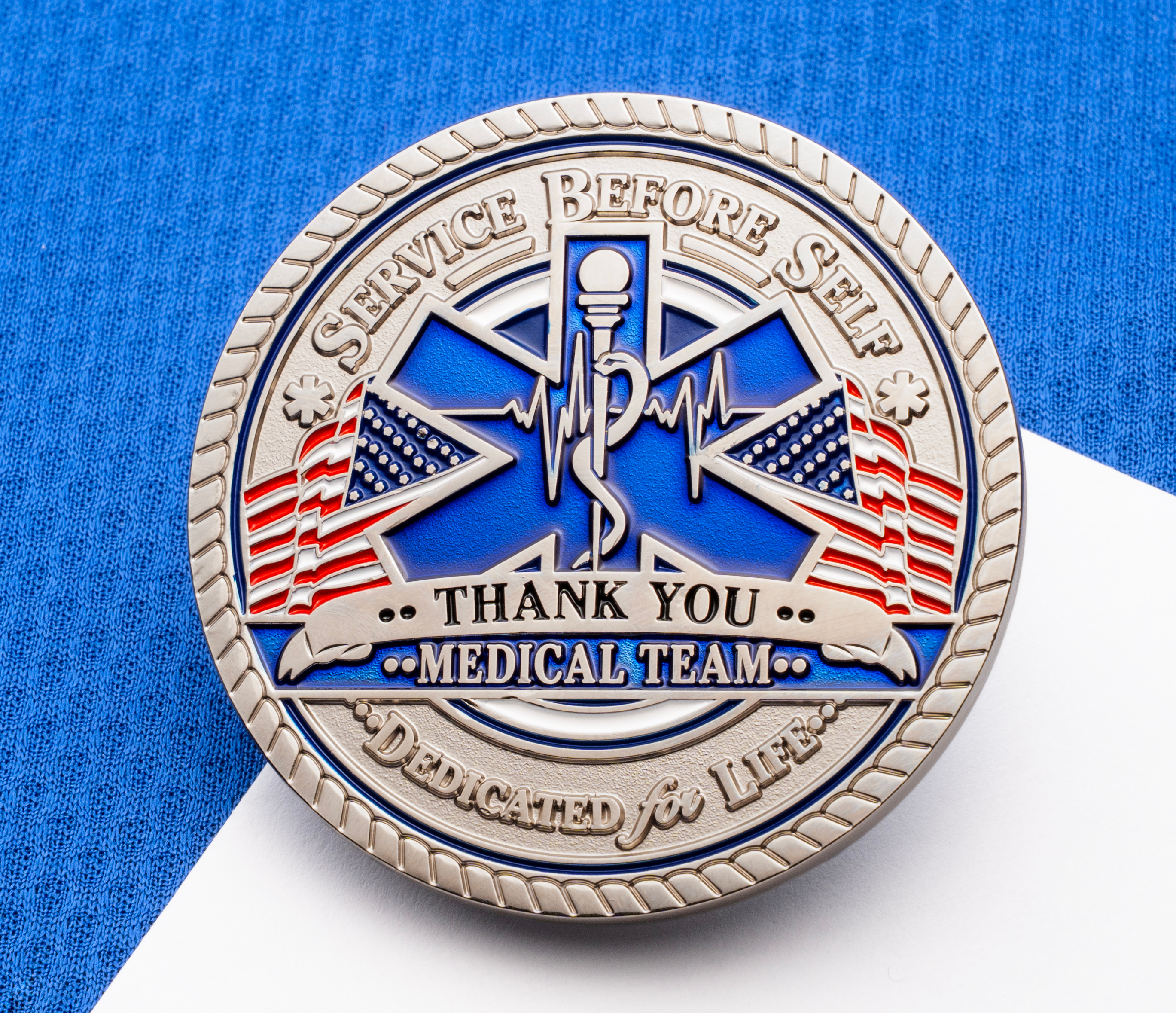 map[name:Silver medical team challenge coin with a blue Star of Life, American flags, and text reading 'Service Before Self' and 'Thank You Medical Team'. naturalSort:Silver medical team challenge coin with a blue Star of Life, American flags, and text reading 'Service Before Self' and 'Thank You Medical Team'.]