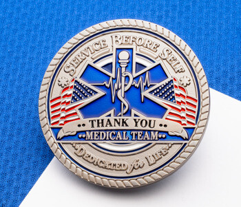 Silver medical team challenge coin with a blue Star of Life, American flags, and text reading 'Service Before Self' and 'Thank You Medical Team'.