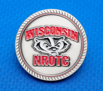 Circular silver medallion featuring the Wisconsin NROTC logo and Bucky Badger mascot in red and black enamel on a blue textured background.