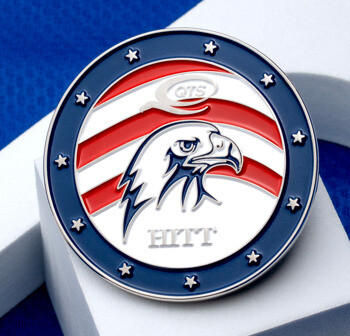Circular challenge coin featuring an eagle head, red and white stripes, and a blue border with stars, displaying QTS and HITT text.