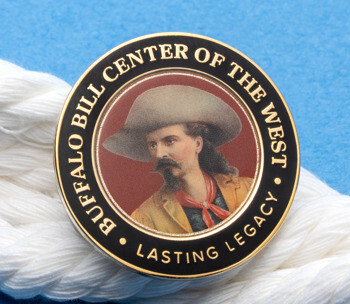Circular lapel pin featuring a portrait of Buffalo Bill with the text Buffalo Bill Center of the West, resting on a white rope over a blue background.
