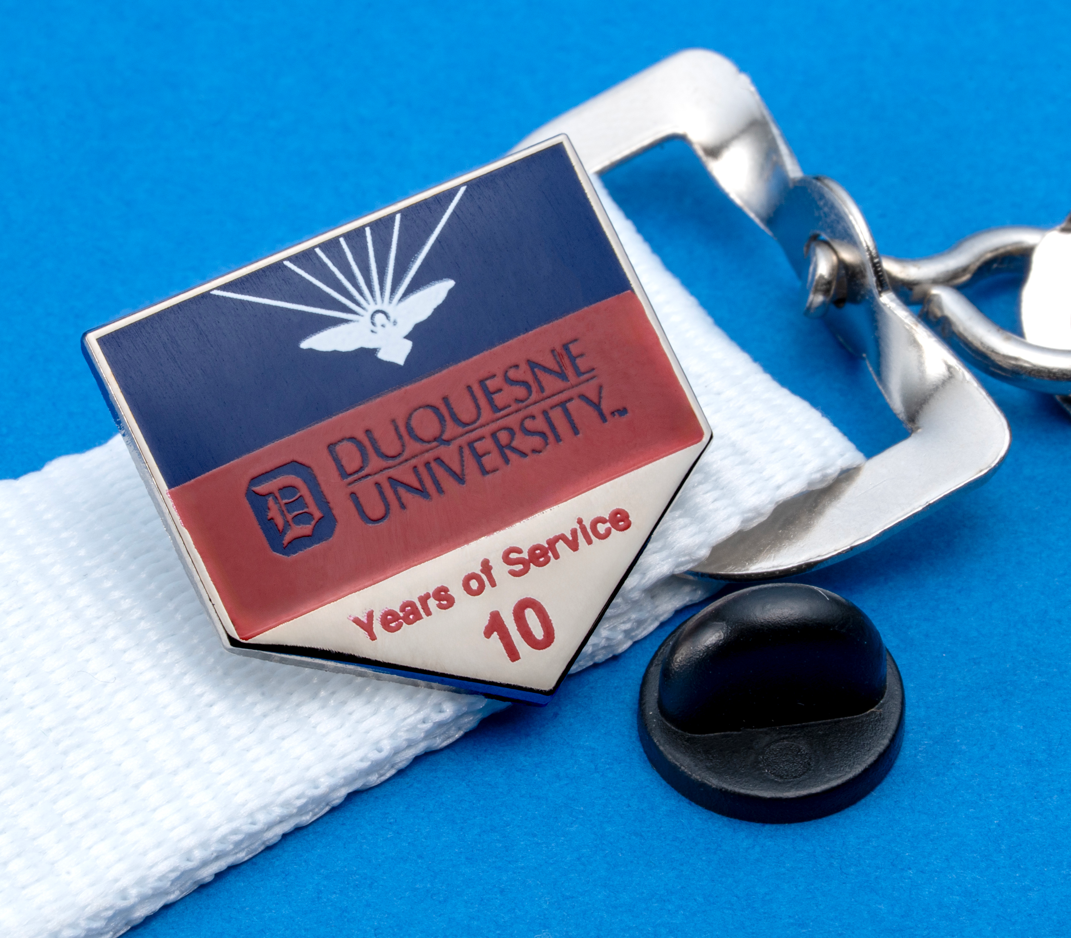 Duquesne University 10 Years of Service lapel pin with blue, red, and silver enamel on a white lanyard.