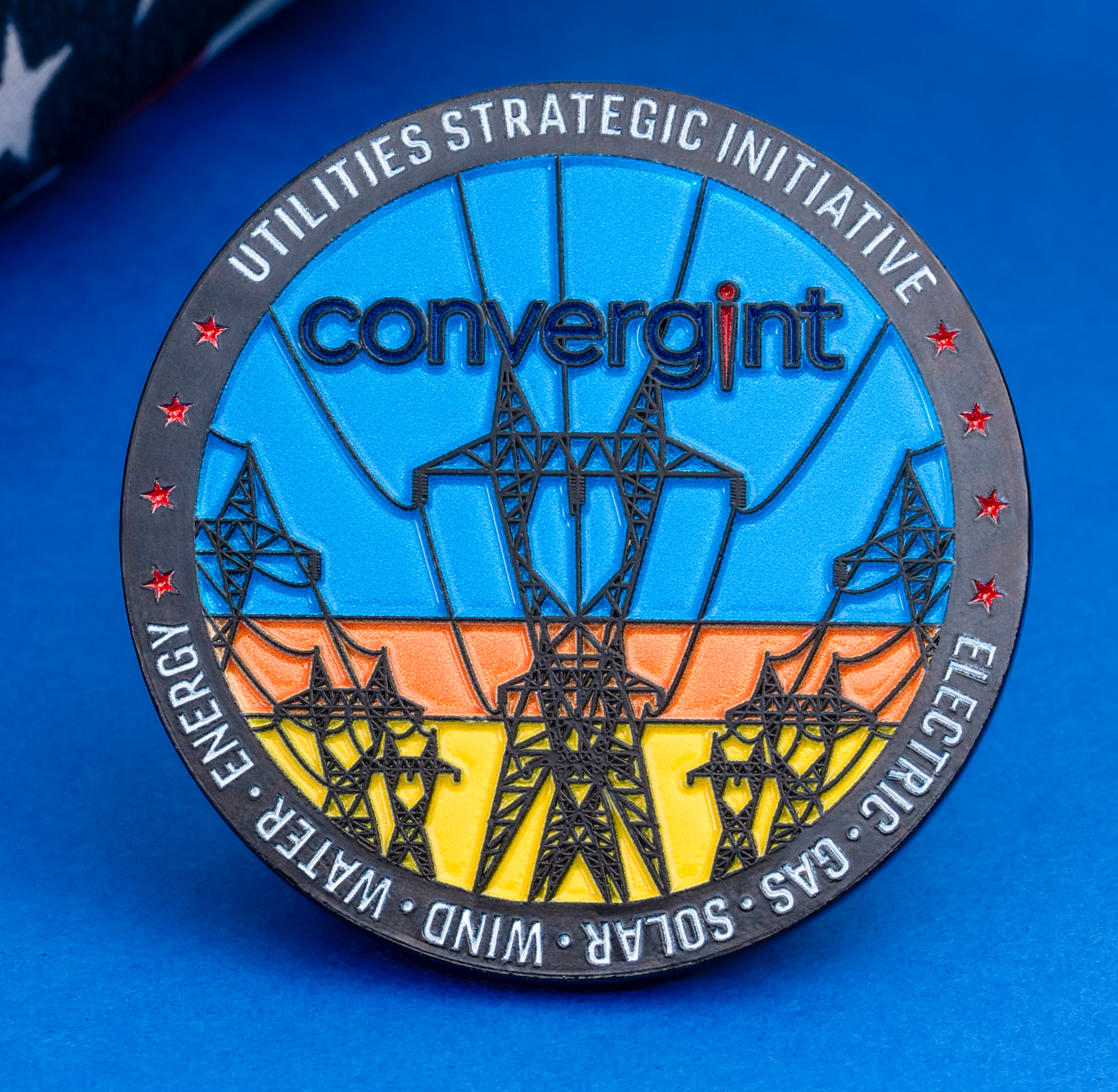 Convergint Utilities Strategic Initiative challenge coin featuring power line towers and red stars next to an American flag.