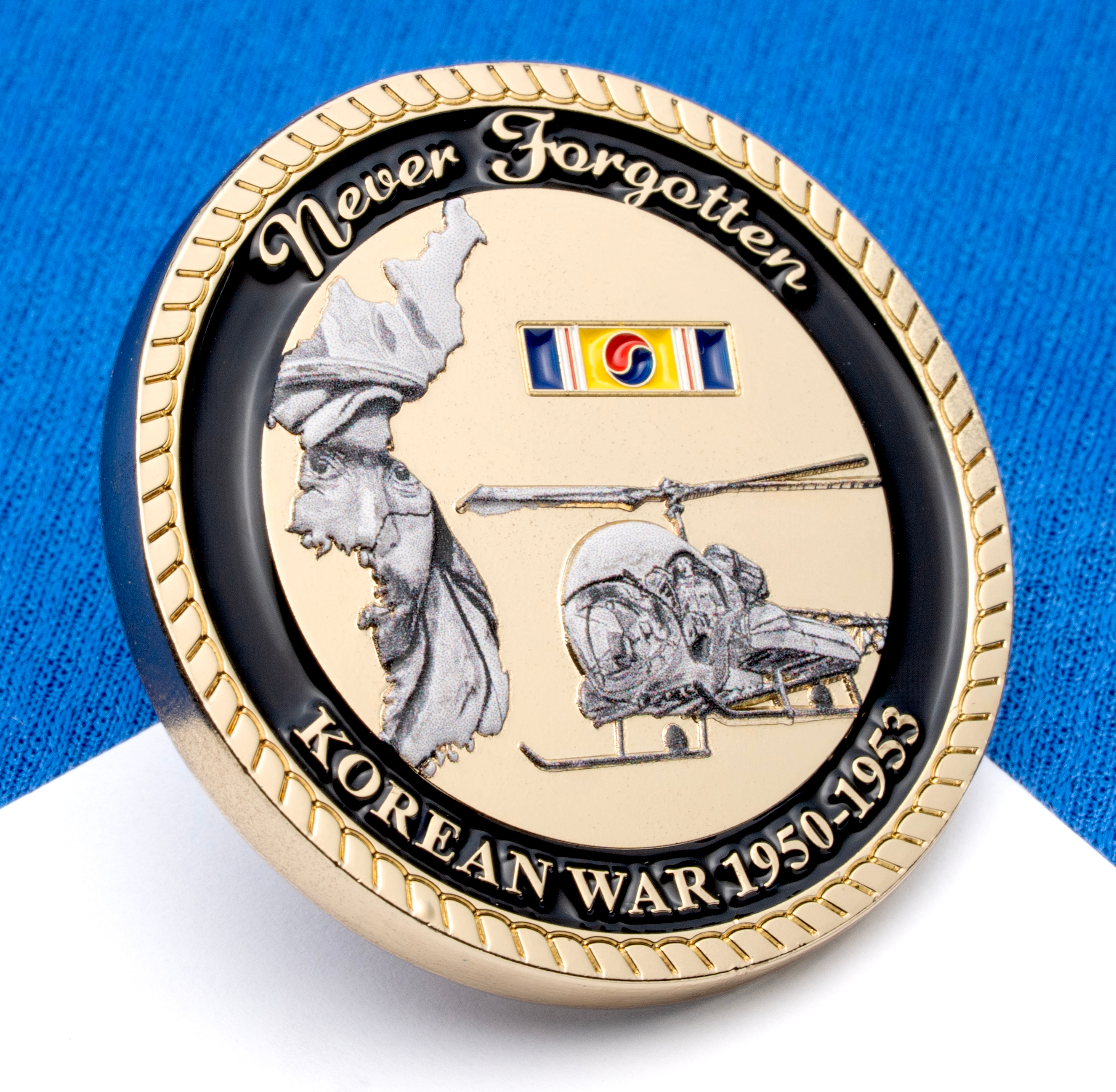 Gold and black challenge coin featuring Korean War 1950-1953 text, a helicopter, and a map of Korea.