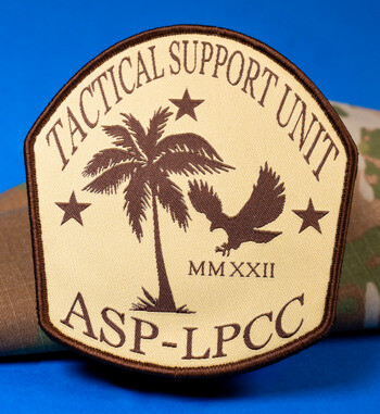 Shield-shaped embroidered patch for Tactical Support Unit ASP-LPCC featuring a palm tree, eagle, and stars in brown on a tan background.