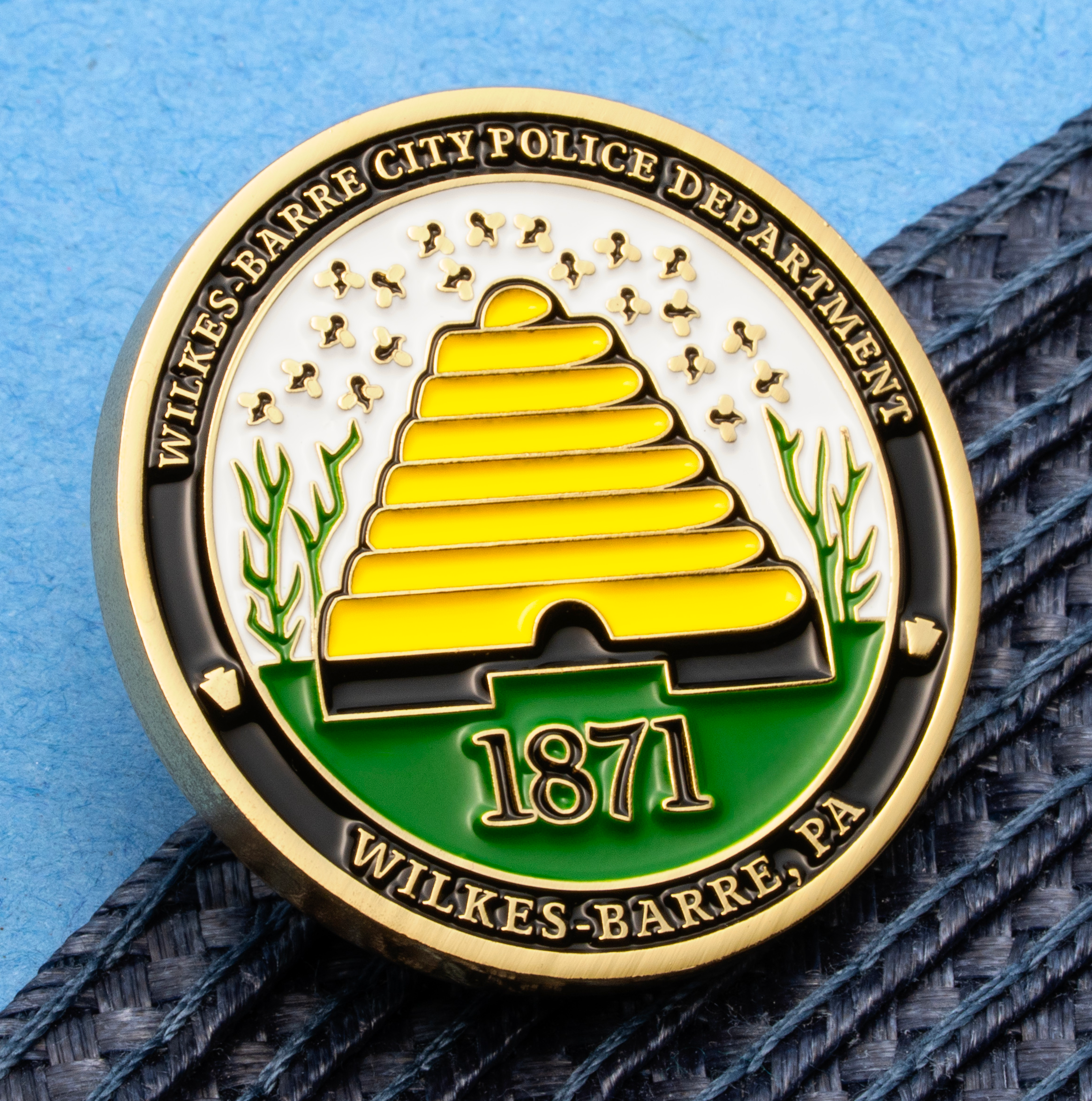 Enamel lapel pin for the Wilkes-Barre City Police Department featuring a yellow beehive, the year 1871, and green accents.