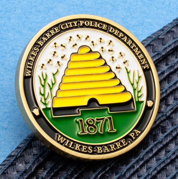 Enamel lapel pin for the Wilkes-Barre City Police Department featuring a yellow beehive, the year 1871, and green accents.