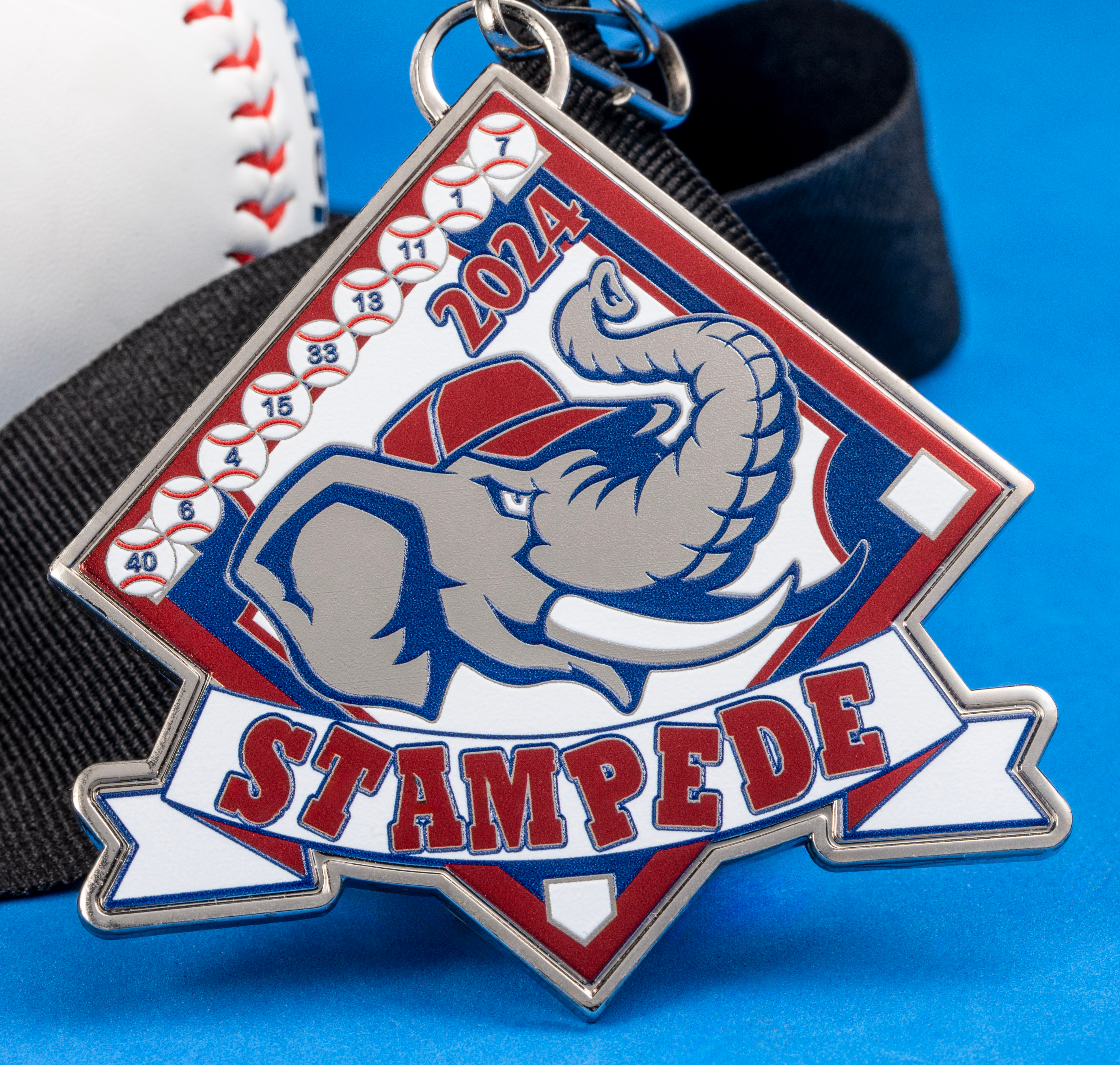 Diamond-shaped enamel medal featuring a cartoon elephant wearing a baseball cap with the text 2024 Stampede, shown next to a baseball.