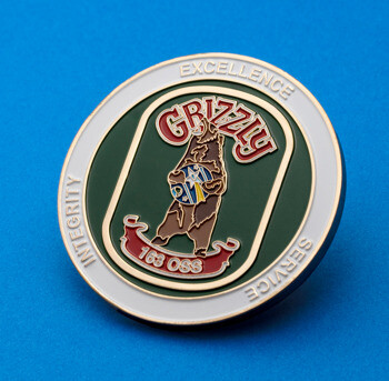 Circular challenge coin featuring a grizzly bear emblem with 163 OSS text on a green and white enamel background.