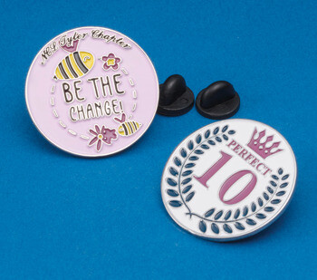 Enamel lapel pins featuring a bee design with 'Be the Change' and a laurel wreath design with 'Perfect 10'.