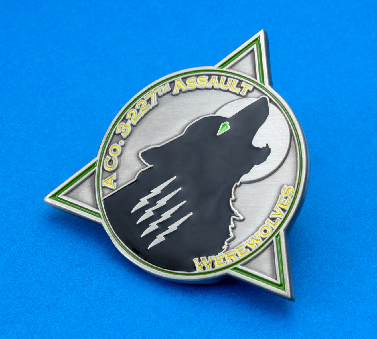 Triangular lapel pin featuring a howling wolf silhouette with lightning bolts and green accents on a silver background.