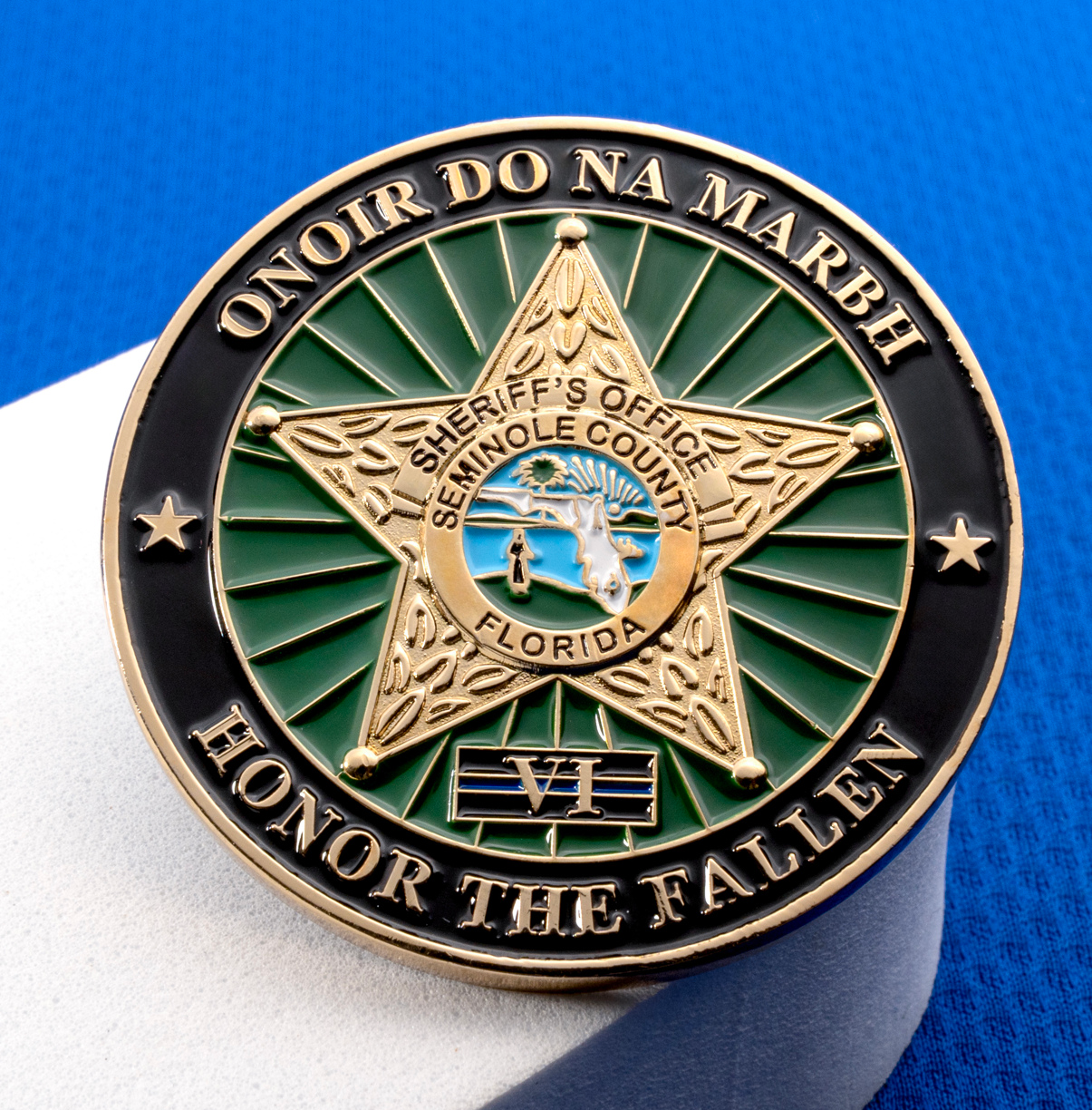 Seminole County Sheriff's Office challenge coin with gold five-point star, green sunburst background, and 'Honor the Fallen' text.