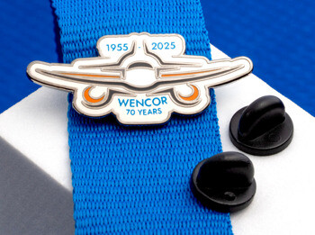 Custom airplane-shaped lapel pin for Wencor 70 years featuring 1955-2025 dates with orange and blue accents.