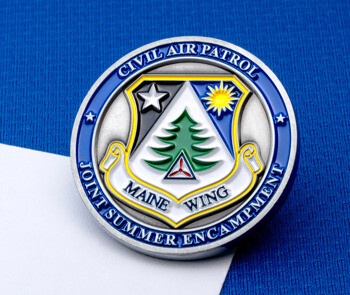 Circular challenge coin for the Civil Air Patrol Maine Wing Joint Summer Encampment featuring a pine tree, sun, and star emblem.