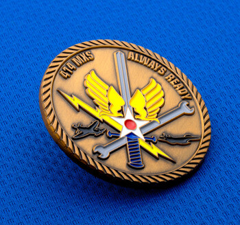 Antique bronze challenge coin featuring 414 MXS text, a sword, wrench, lightning bolt, and winged star emblem on a blue background.