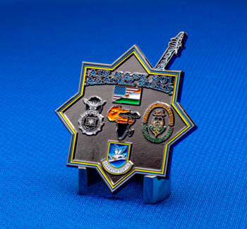 Star-shaped challenge coin for Air Base 201 Agadez Niger featuring military emblems, flags, and an outline of Africa on a black background.