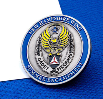 Circular silver and blue challenge coin for New Hampshire Wing Cadet Programs Summer Encampment featuring a yellow-winged eagle and star emblem.