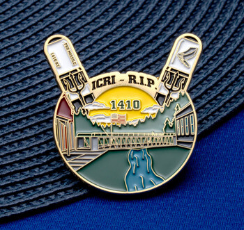Gold-trimmed lapel pin featuring ICRI - R.I.P. 1410 text, tridents, and a landscape with a bridge and flag.