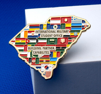 South Carolina shaped lapel pin filled with colorful international flags and the text International Military Student Office.