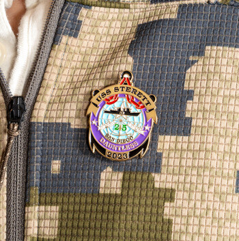 USS Sterett San Diego lapel pin with anchor design and ship silhouette on a digital camouflage jacket.