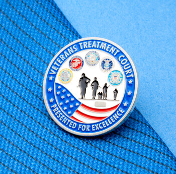 Veterans Treatment Court lapel pin featuring military branch seals, an American flag design, and silhouettes of service members.