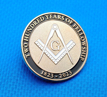 Circular lapel pin featuring the Masonic square and compass symbol with 'Two Hundred Years of Fellowship' and '1823 - 2023' text.