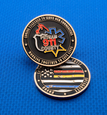 Custom challenge coin for Putnam 911 County featuring emergency service emblems and a thin line flag design on a blue textured background.