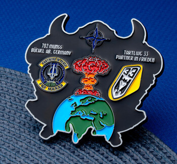 Custom shaped challenge coin featuring 702 MUNSS, TaktLwG 33, a mushroom cloud over Earth, and a NATO star.