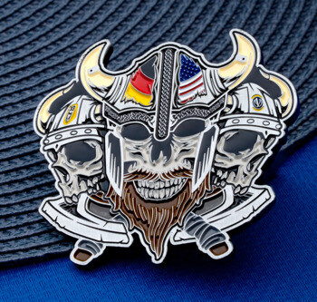 Enamel lapel pin featuring three viking skulls wearing horned helmets with German and American flags and crossed axes.