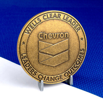 Antiqued bronze Chevron challenge coin with Wells Clear Leader design on a blue textured background