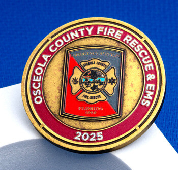 Osceola County Fire Rescue & EMS challenge coin with a red and gold emblem, Maltese cross, and the year 2025 displayed on a blue background.