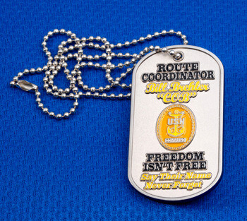 Custom silver dog tag style challenge coin with a ball chain necklace, featuring yellow USN Command emblem and engraved text on a blue background.