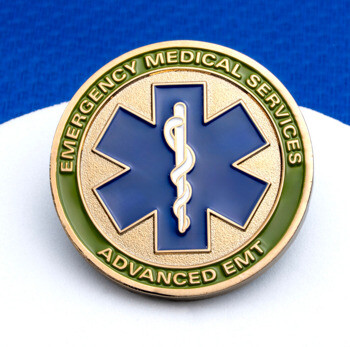 Circular Emergency Medical Services Advanced EMT lapel pin featuring a blue Star of Life with a Rod of Asclepius on a gold and green textured background.