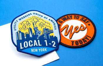 Utility Workers Union of America Local 1-2 embroidered patch with New York skyline and a circular orange and white embroidered patch on a blue background.