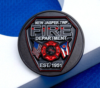 Round black metal challenge coin for New Jasper Twp Fire Department featuring a red maltese cross, US flag, Ohio flag, and "Est. 1951".