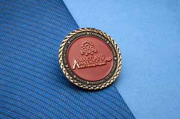 Round lapel pin featuring the Maryland Apprenticeship and Training Program logo in red and gold with a textured diamond-cut edge.