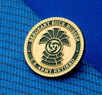 Gold and black lapel pin for Sergeant Buck Musser, U.S. Army Retired, featuring a master sergeant rank insignia and rope border.