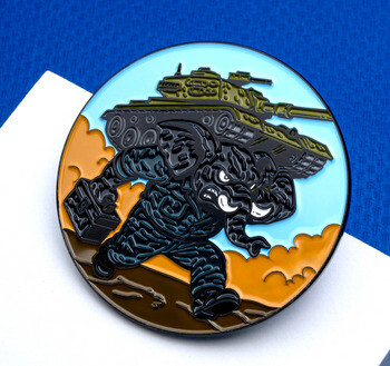 Round enamel lapel pin depicting a muscular elephant mascot in uniform carrying a military tank on its back against a desert sky.