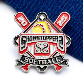 Showstopper Softball 2025 trading lapel pin featuring crossed bats, a yellow softball, and red enamel accents displayed on a blue cap.