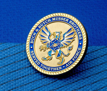 Gold challenge coin with the US Air Force logo and blue enamel border featuring the names Buck and Butch Musser Brothers.