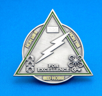 Triangular challenge coin with a lightning bolt, military rank insignias, and the text For Excellence.